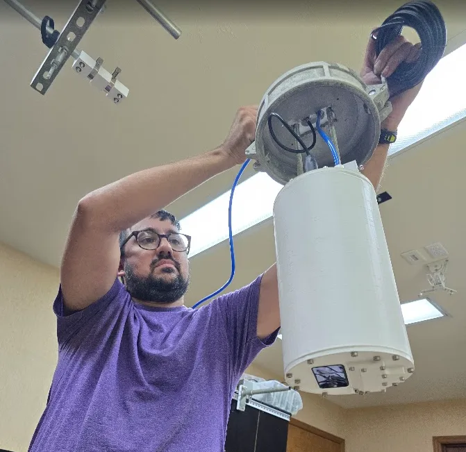 William Dueease holding a prototype air knife LiDAR sensor for silos