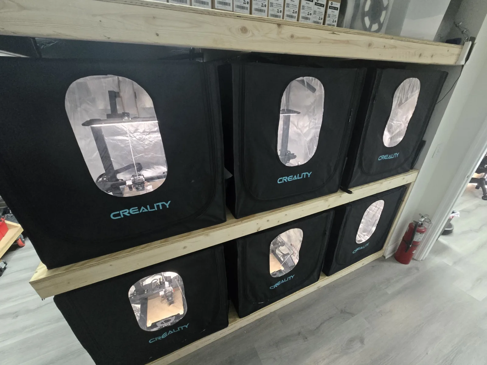 Six enclosed 3D printers on wooden shelving in the Altamus shop