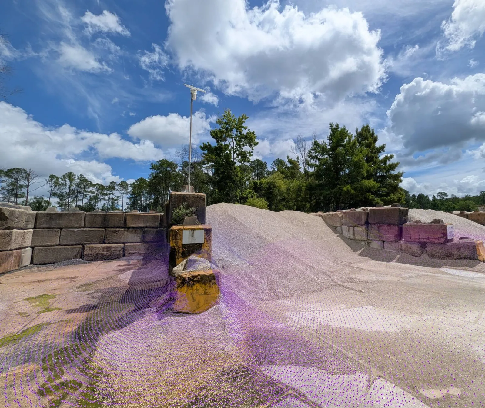 Pole-mounted EOS2 LiDAR sensor above an aggregate bin, with its point cloud overlaid on the stockpile