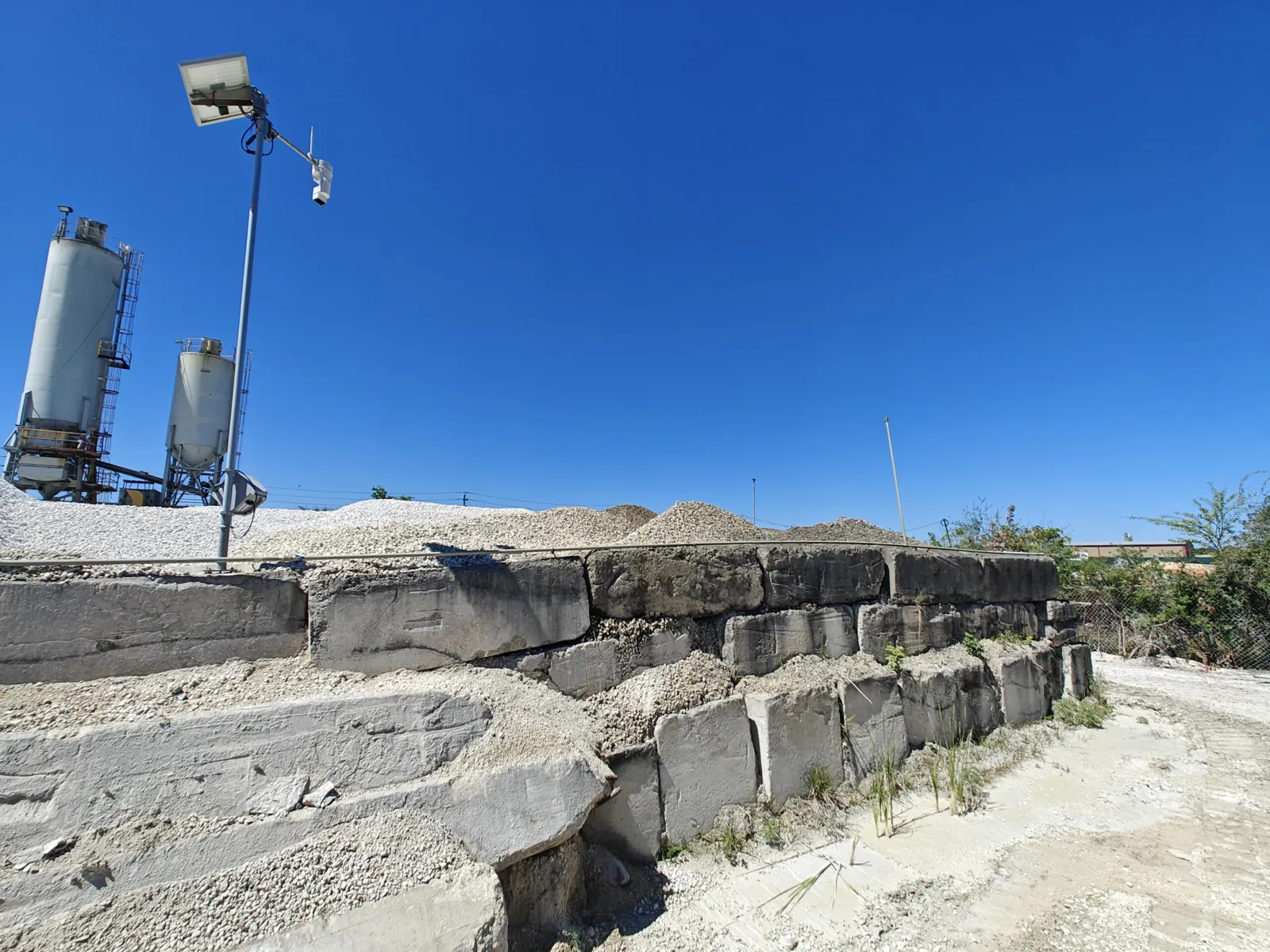 EOS2 sensor on a pole above the aggregate stockpiles at a ready-mix concrete plant