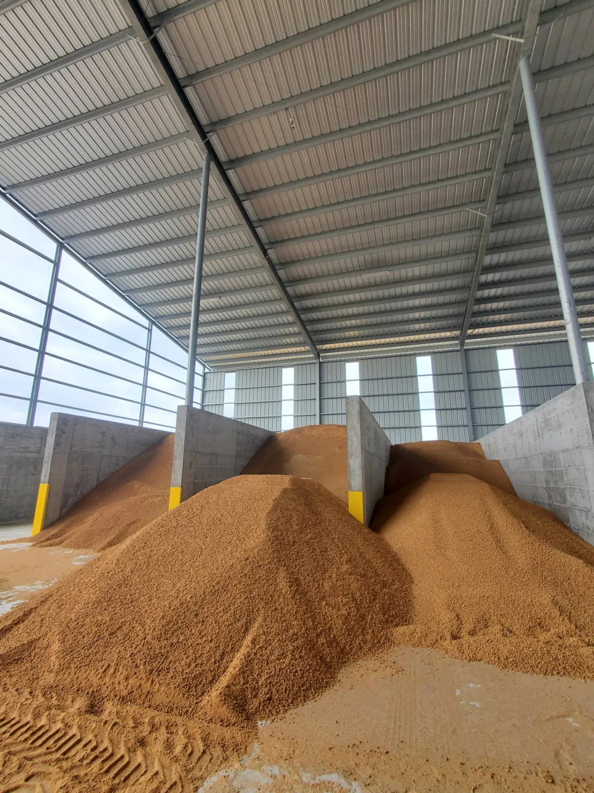 Feed commodity piles in concrete bays under a covered storage building