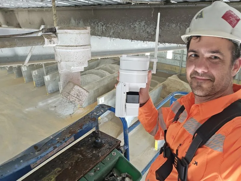 Altamus engineer installing an EOS2 LiDAR sensor from a lift above feed commodity bays