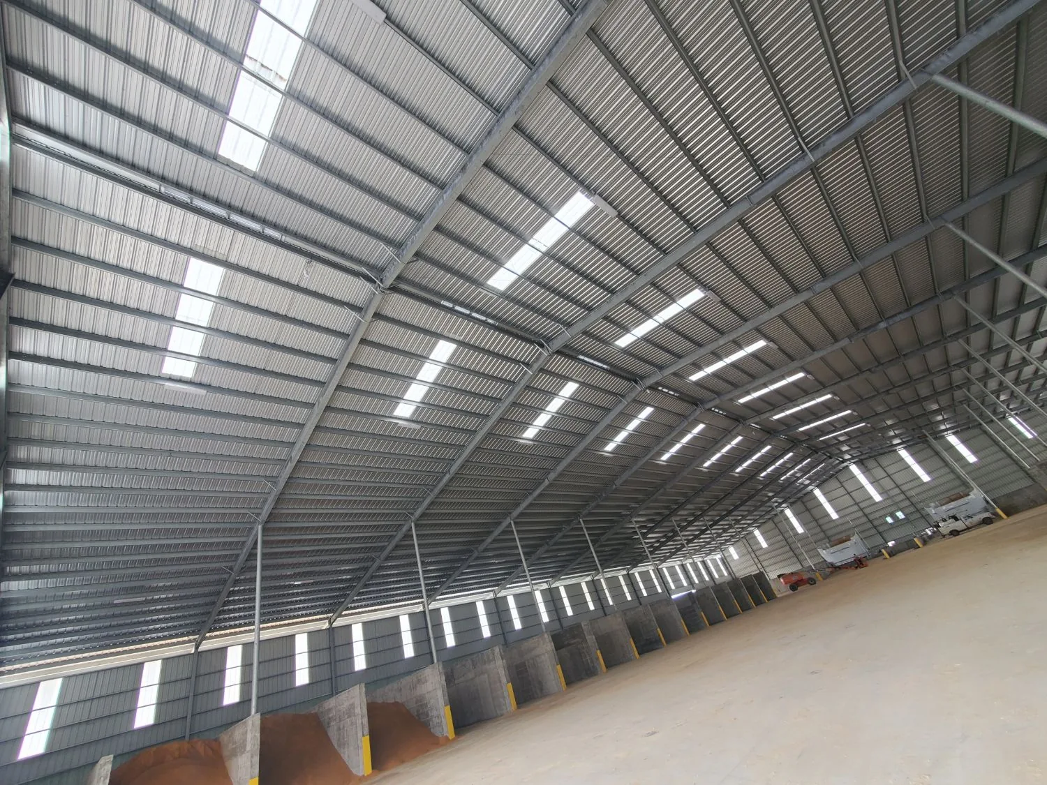 Covered feed storage building with a row of concrete commodity bays monitored by Hyperion