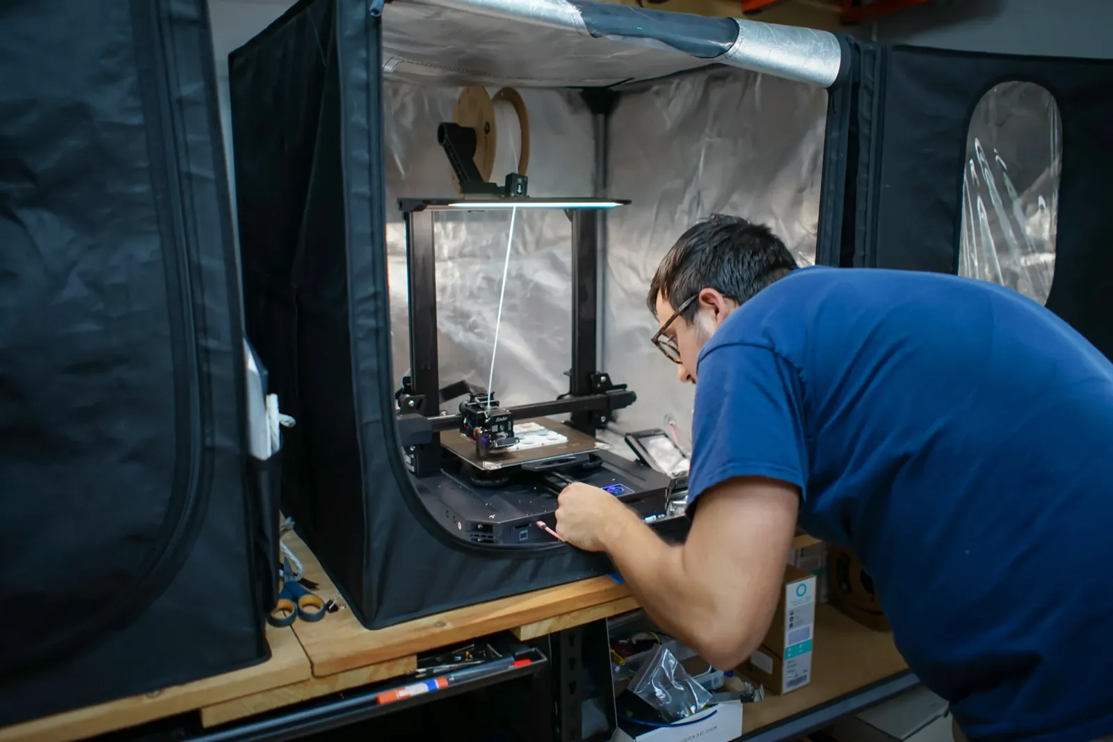 Altamus engineer setting up a 3D printer inside an enclosure in the prototyping lab