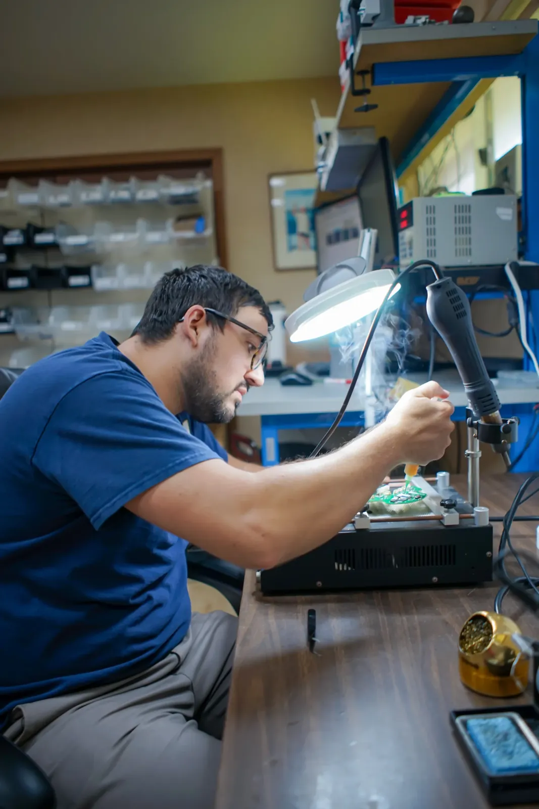 Altamus engineer assembling a prototype at an electronics bench with a microscope