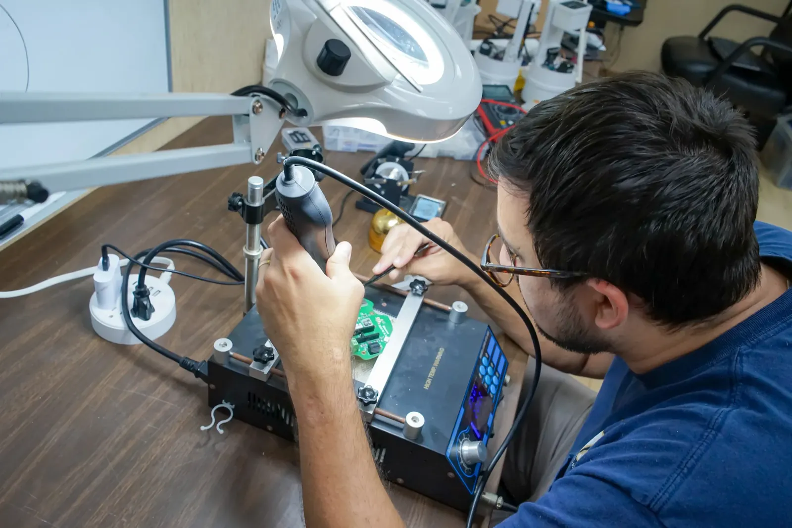 Engineer reworking a printed circuit board during hardware design and prototyping at Altamus