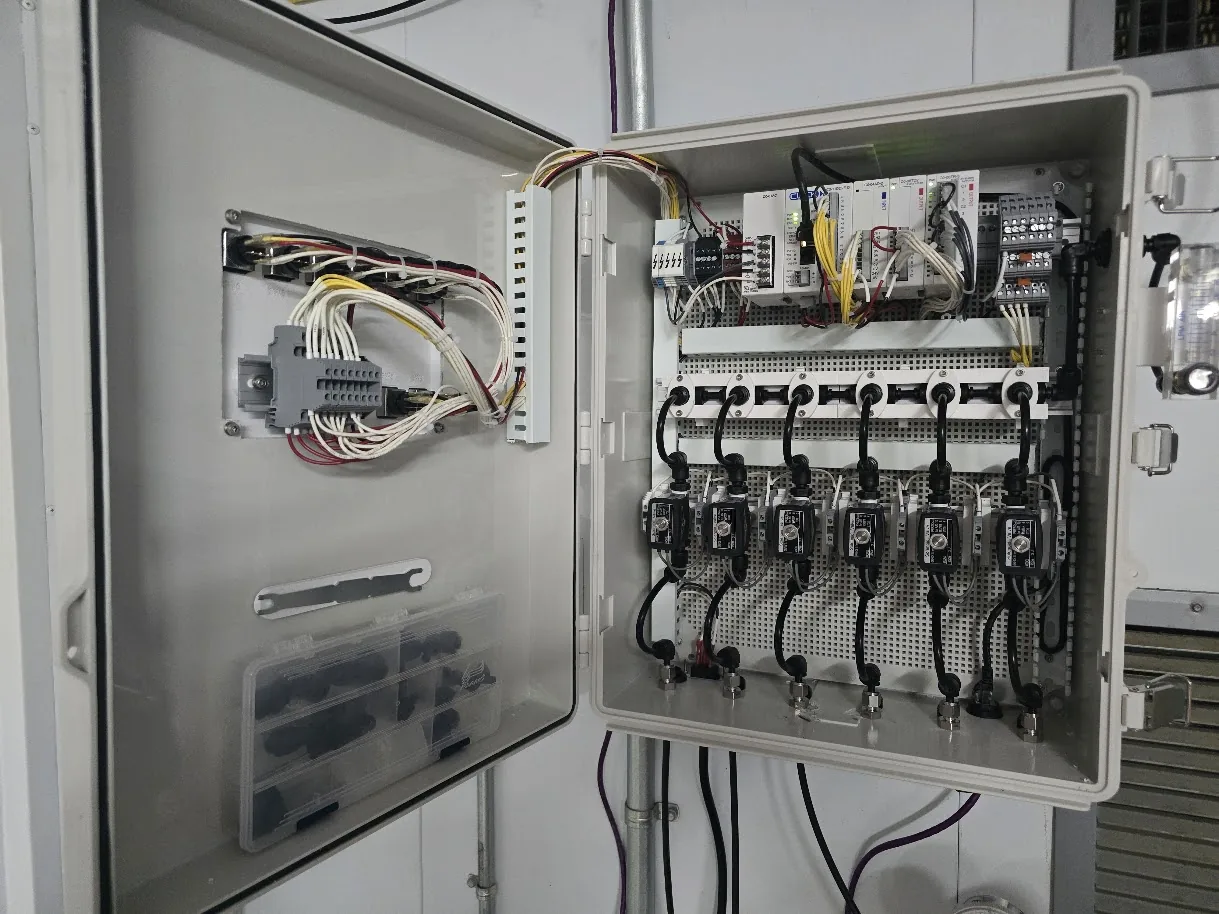 Custom control enclosure built by Altamus, with a PLC, I/O modules, terminal blocks and a row of six solenoid valves plumbed to tubing fittings