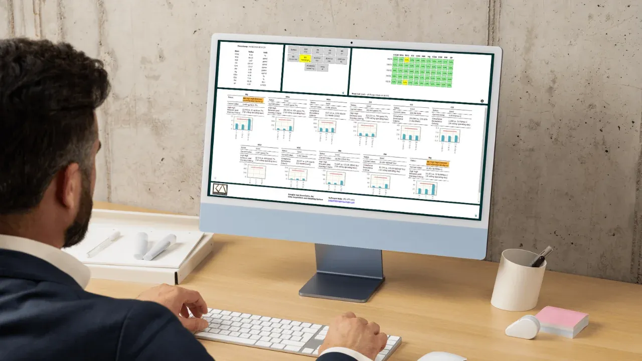 Environmental manager reviewing STACguard emissions data on a desktop monitor